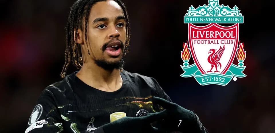 Player gesturing during match with Liverpool logo background