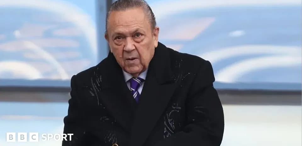 Man in a black coat at sports event