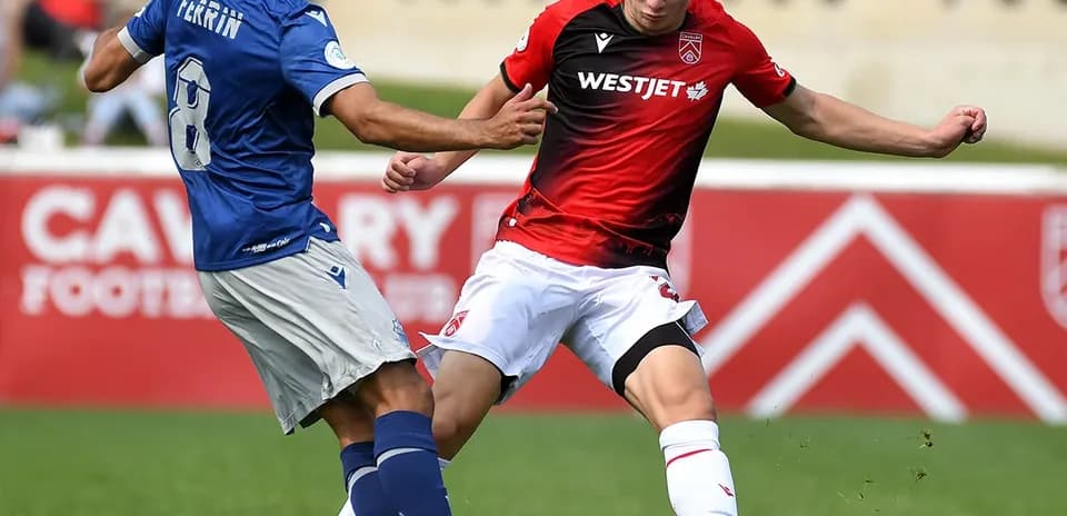 Cavalry FC player tackling HFX Wanderers FC opponent