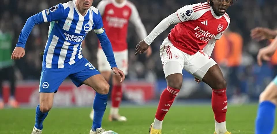 Brighton player challenges Arsenal player for the ball