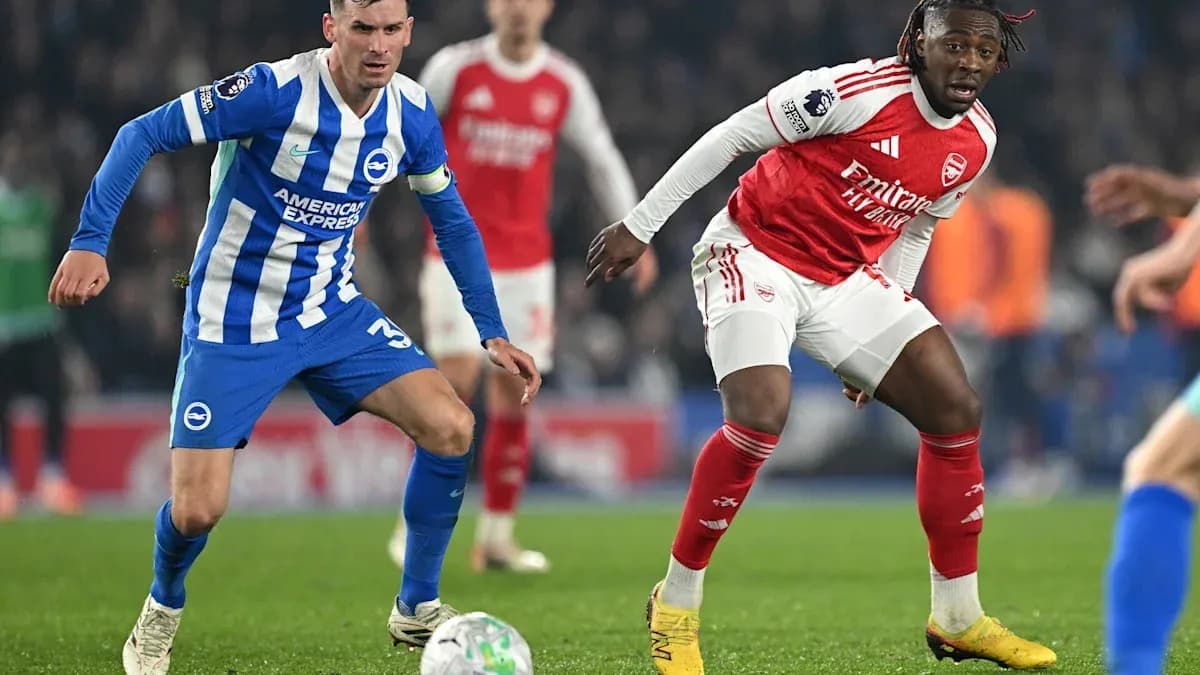 Brighton player challenges Arsenal player for the ball
