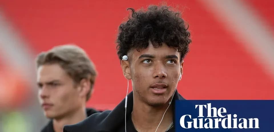 Two young men walking with earbuds in stadium