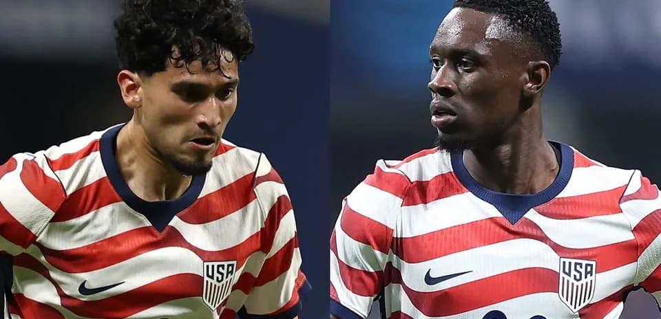 Two USA soccer players in striped jerseys on field