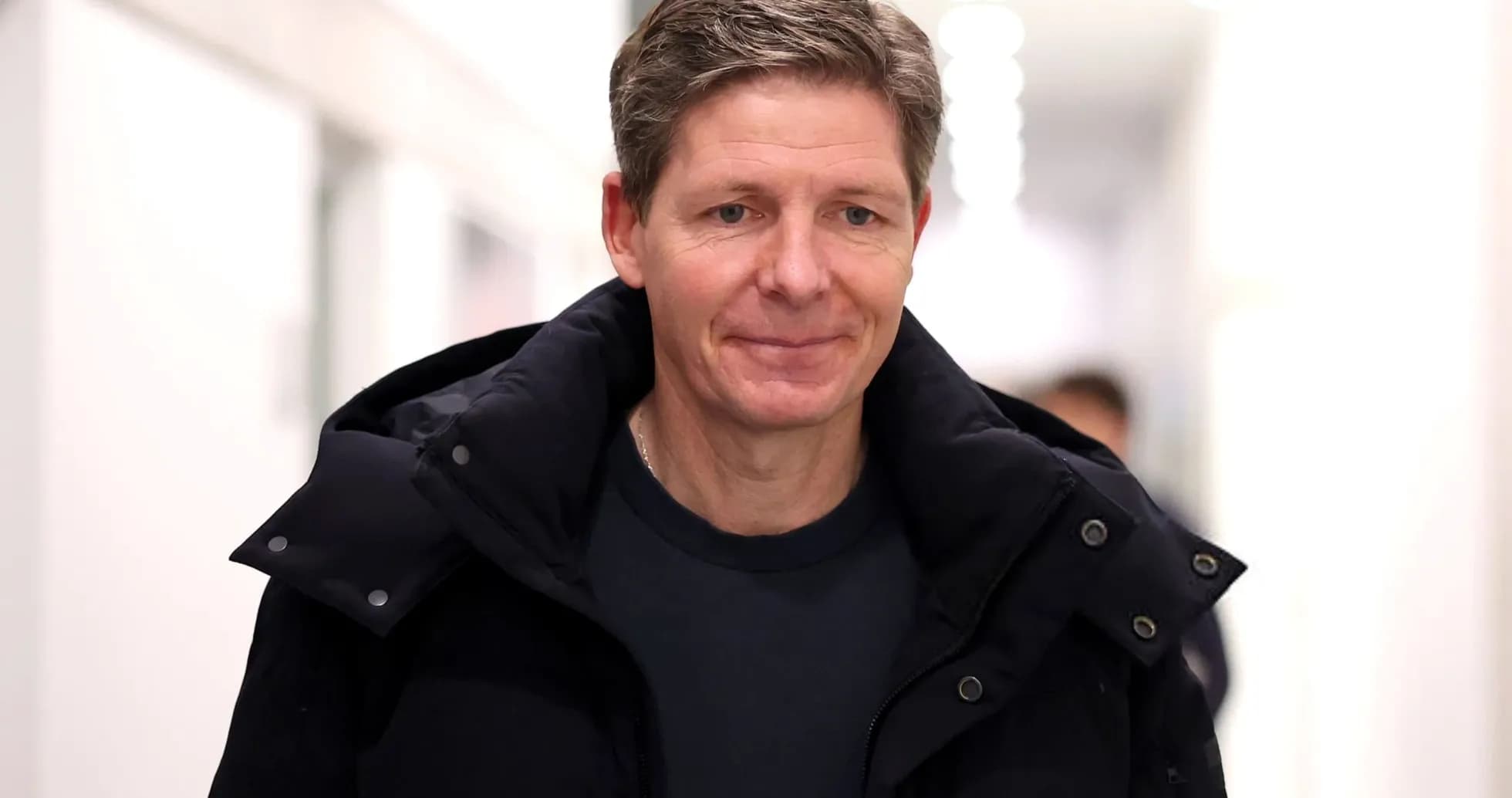 Man walking in a hallway wearing a dark jacket