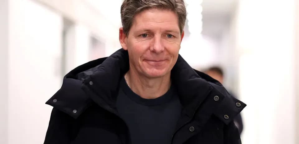 Man walking in a hallway wearing a dark jacket