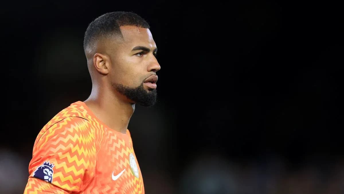 Goalkeeper in orange kit during match warm-up