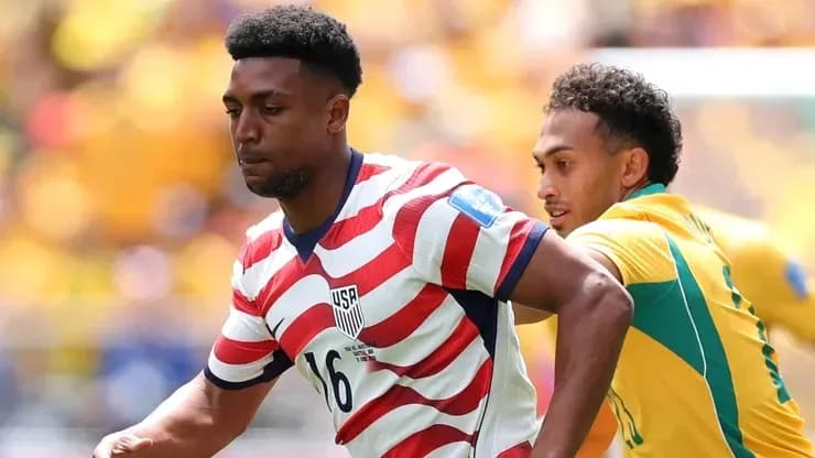 Player in USA kit being pursued by opponent