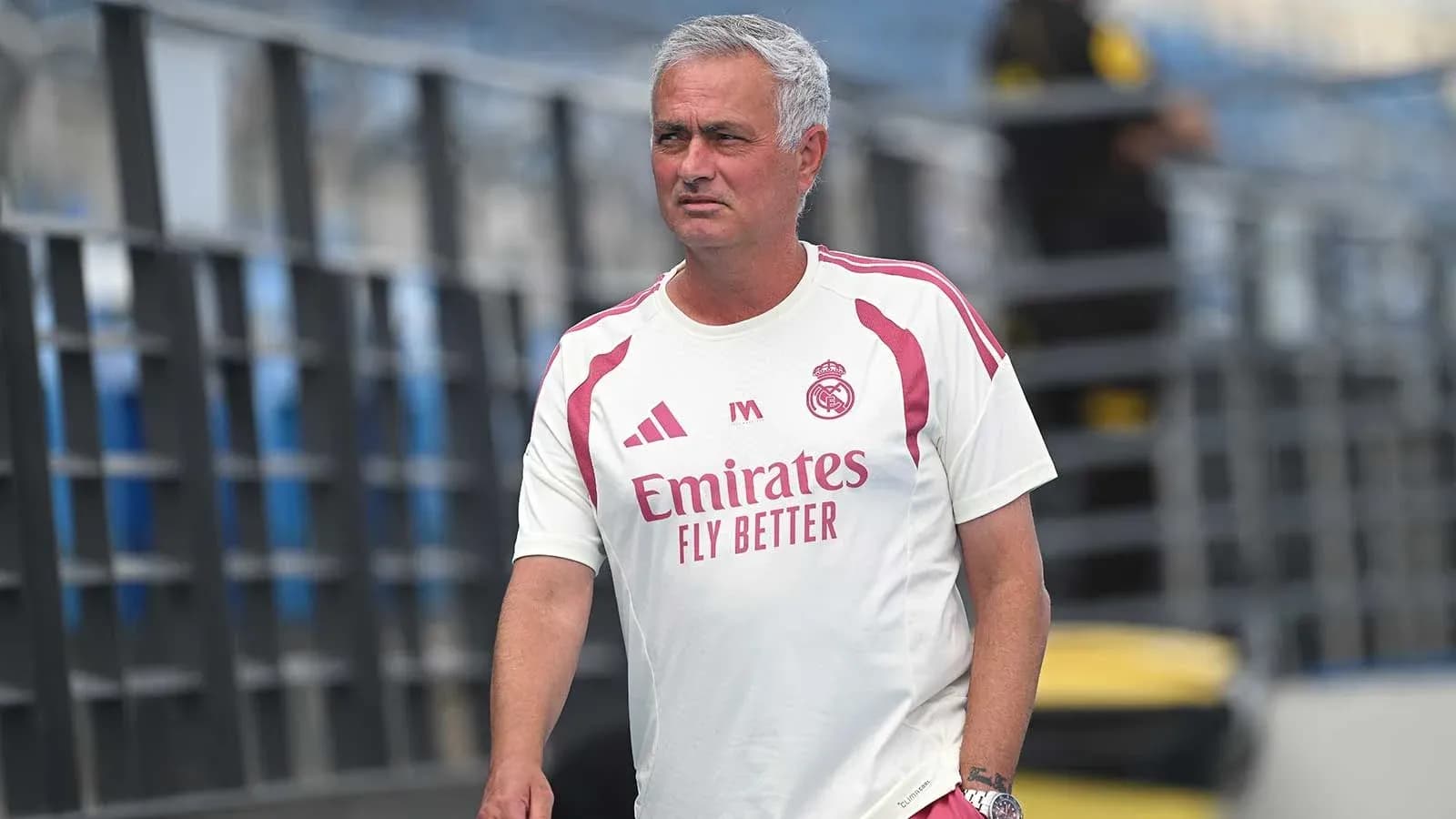 Coach walking on training pitch in team apparel