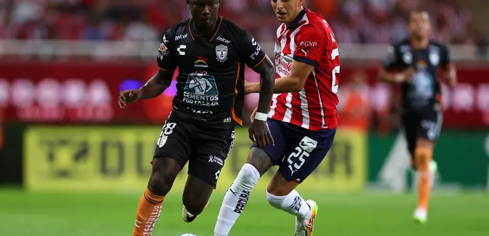 Two players competing for the ball in Liga MX