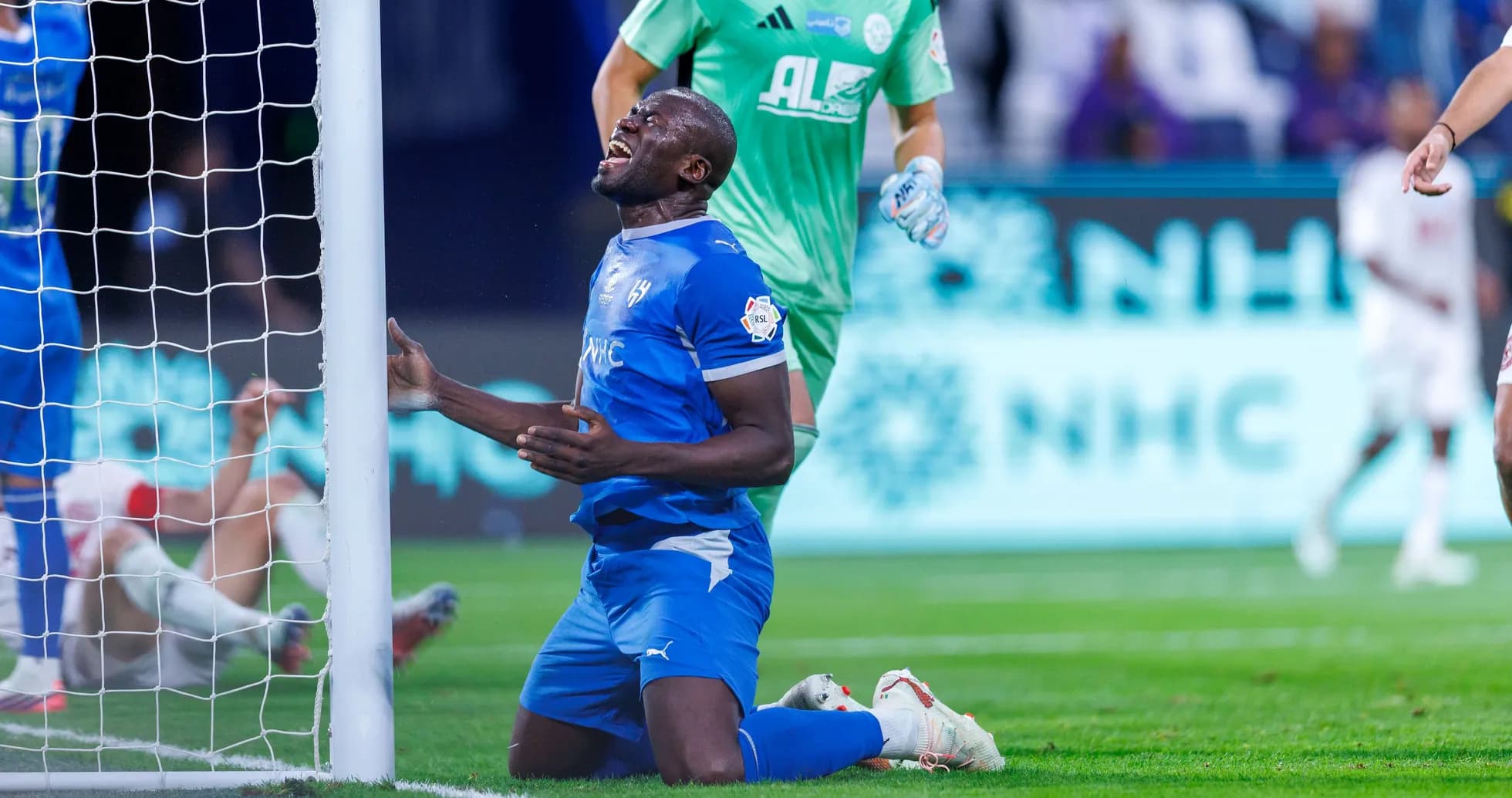 Player kneeling in front of goalpost after missing chance