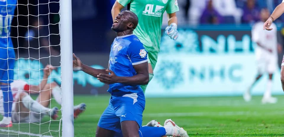 Player kneeling in front of goalpost after missing chance