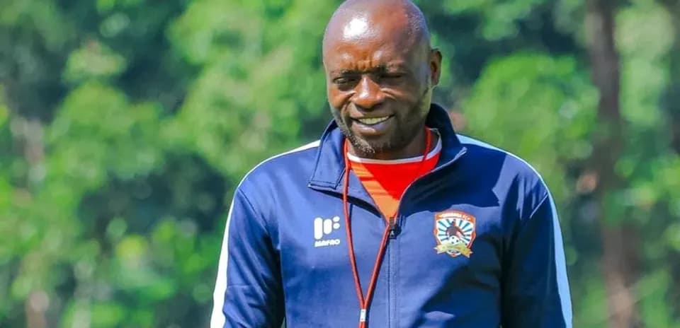 Coach walking on training ground in team tracksuit