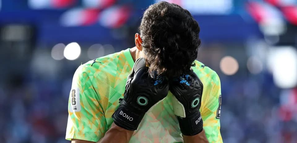Goalkeeper holding head in hands on field