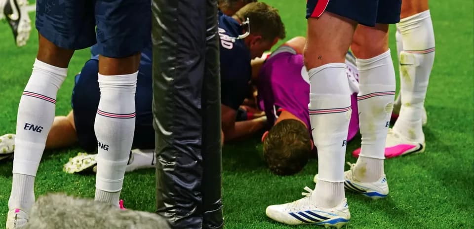 Players attending to an injured teammate on field