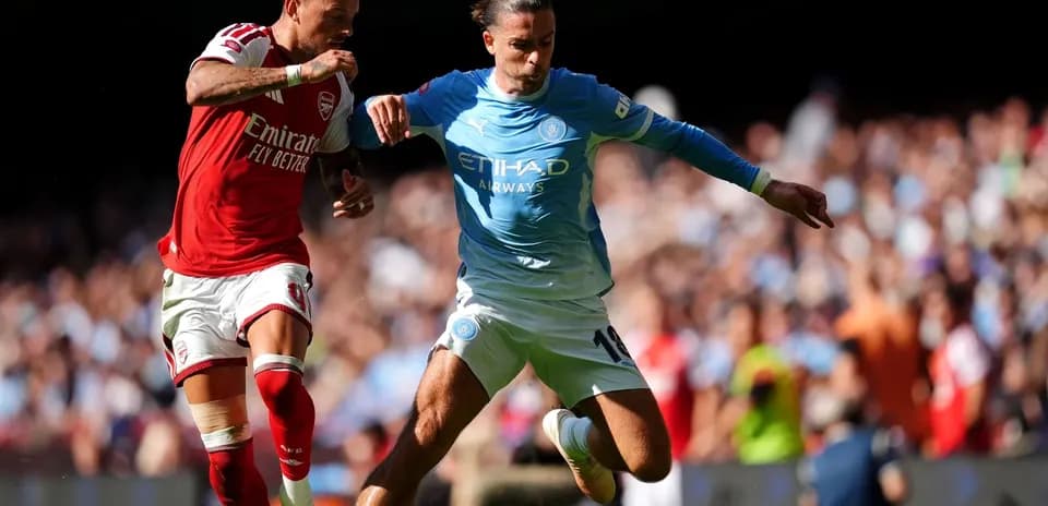 Players from Arsenal and Manchester City battling for the ball