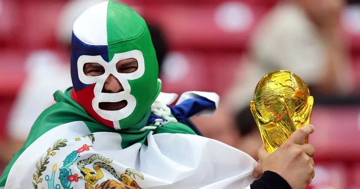 Fan wearing mask holding FIFA World Cup trophy