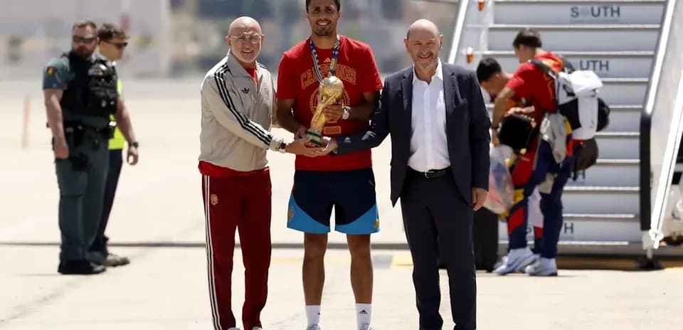 Player holding trophy with officials at airport