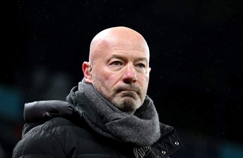 Man wearing a coat and scarf at a match