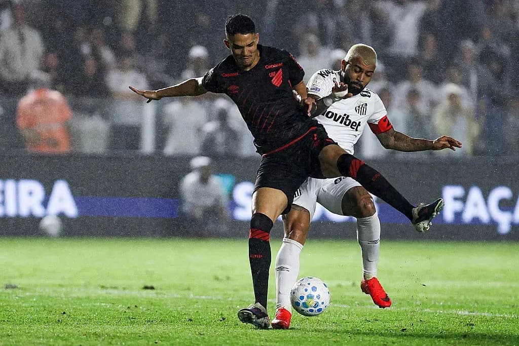 Player tackling opponent during a rainy football match