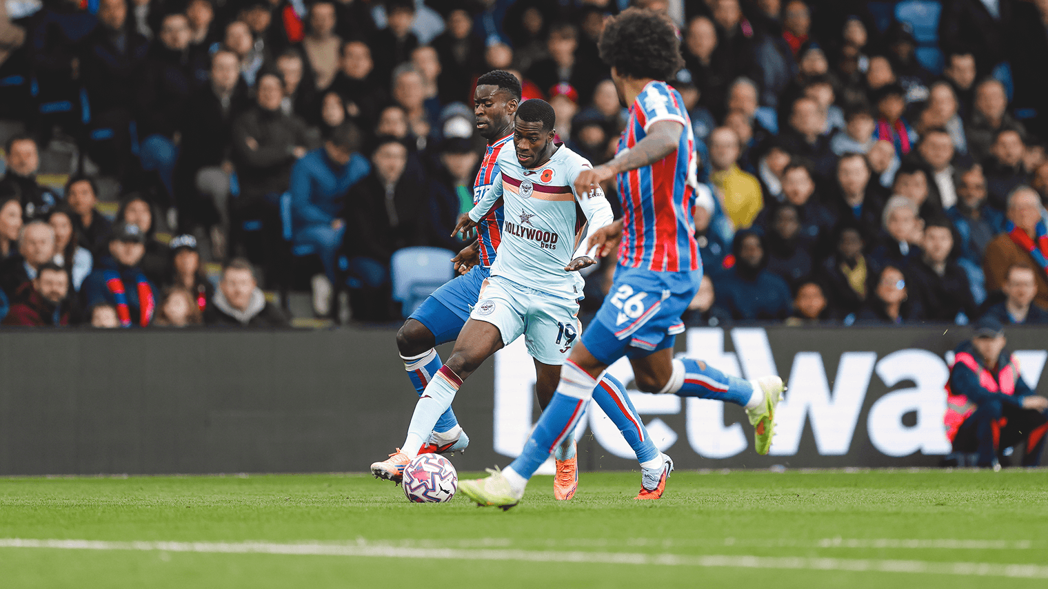 Brentford player challenged by Crystal Palace defenders