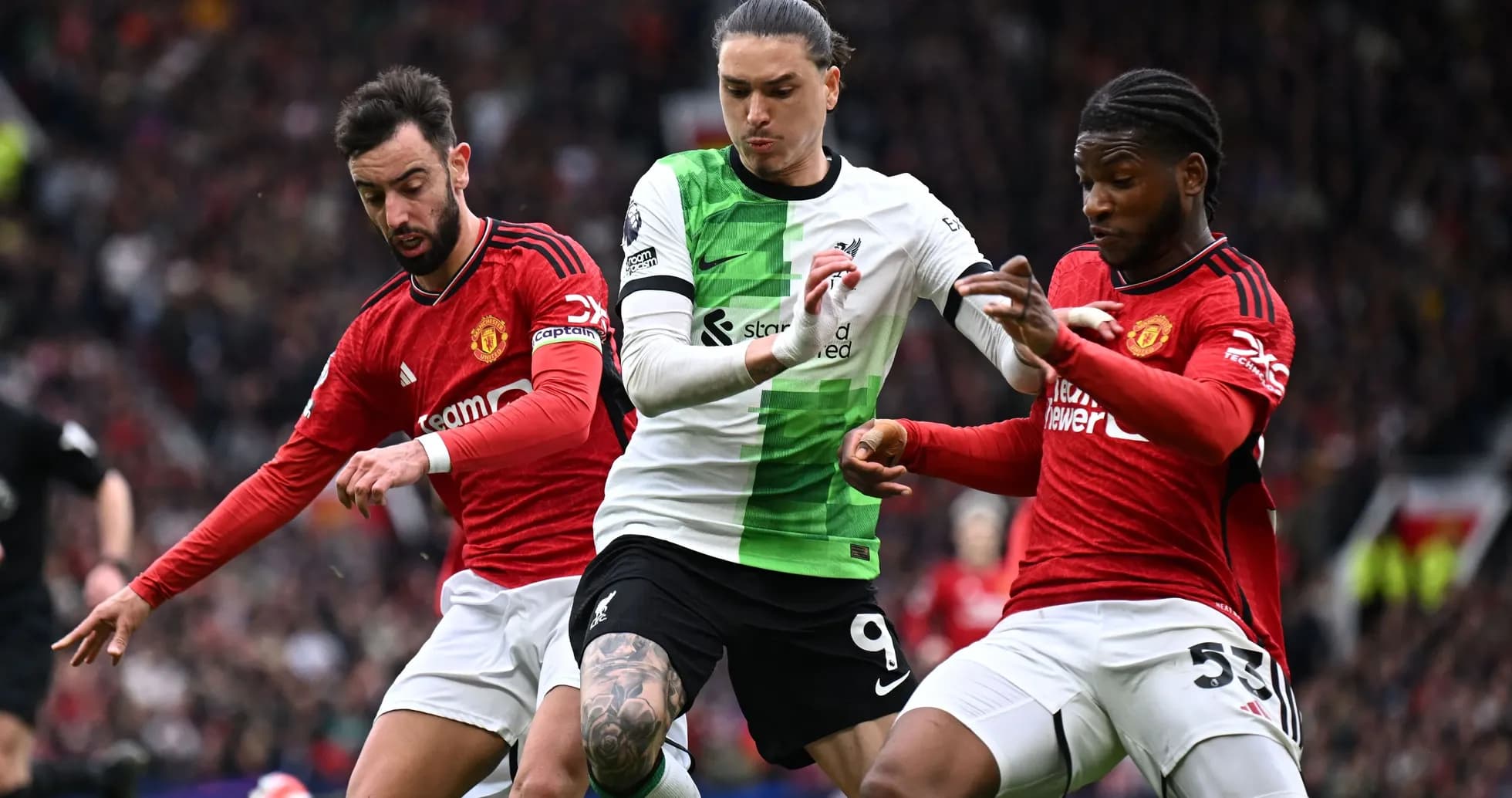 Players from Liverpool and Manchester United contesting possession