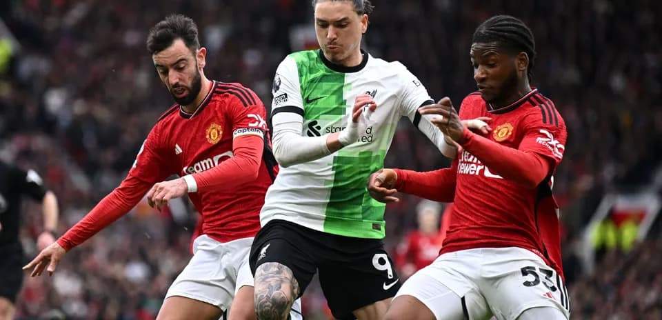 Players from Liverpool and Manchester United contesting possession