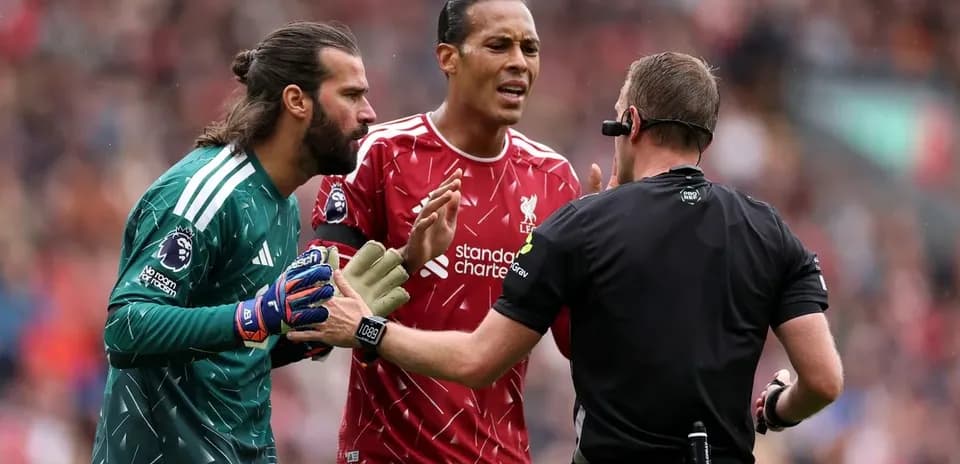 Liverpool players arguing with referee during match