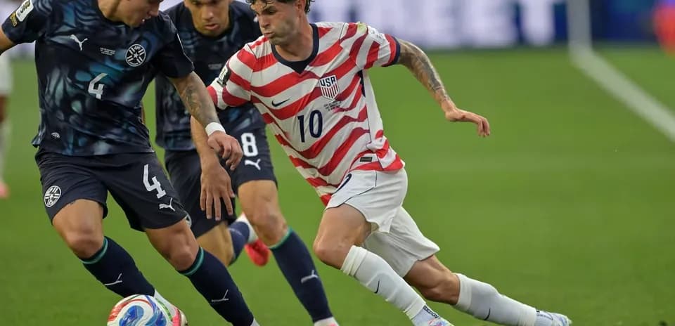 Christian Pulisic dribbling past opposing players