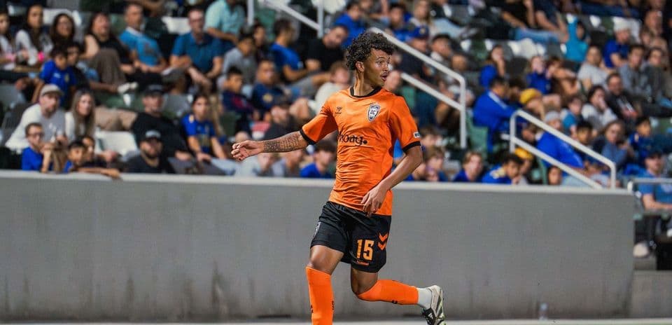 Player in orange jersey dribbling the ball