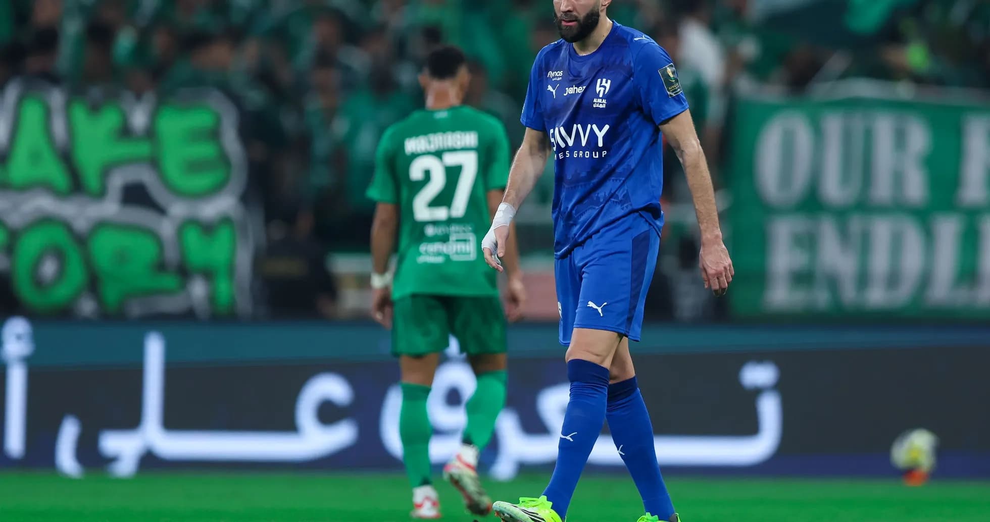 Player in blue kit walking on the pitch