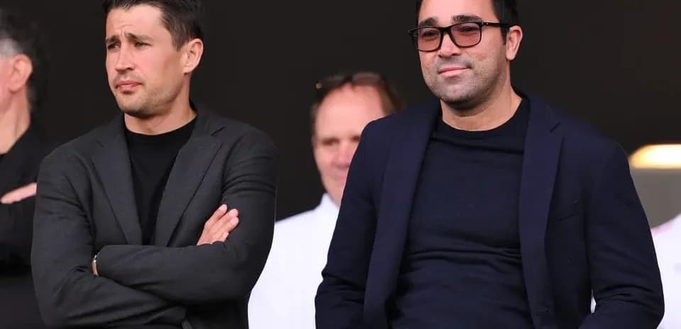 Two men seated in a sports venue viewing event