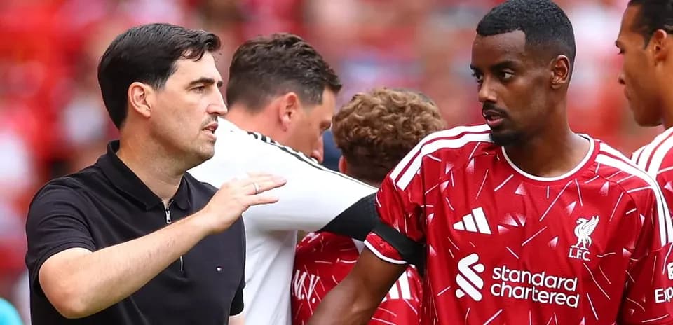 Coach discussing strategy with Liverpool player on pitch