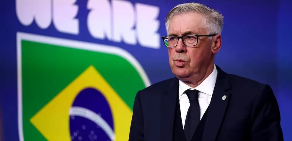 Football manager speaking in front of Brazil flag