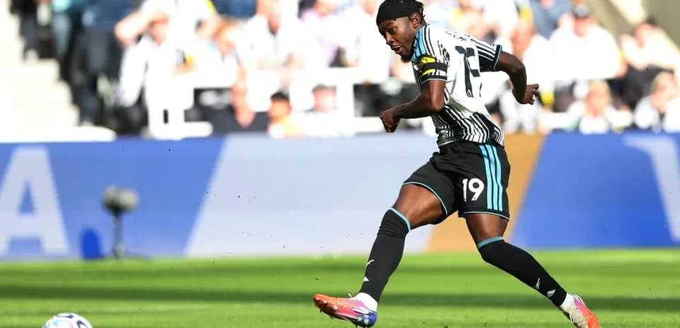 Player in Newcastle kit kicking a soccer ball