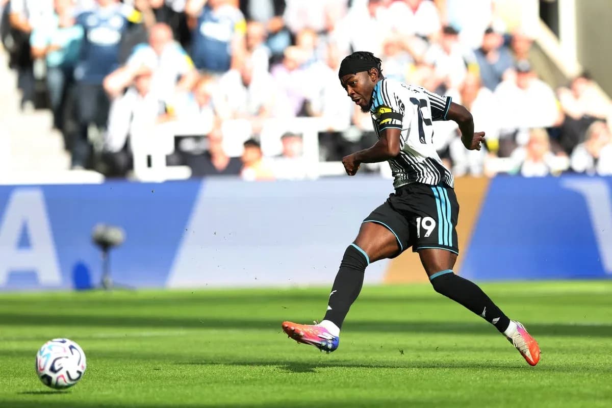 Player in Newcastle kit kicking a soccer ball