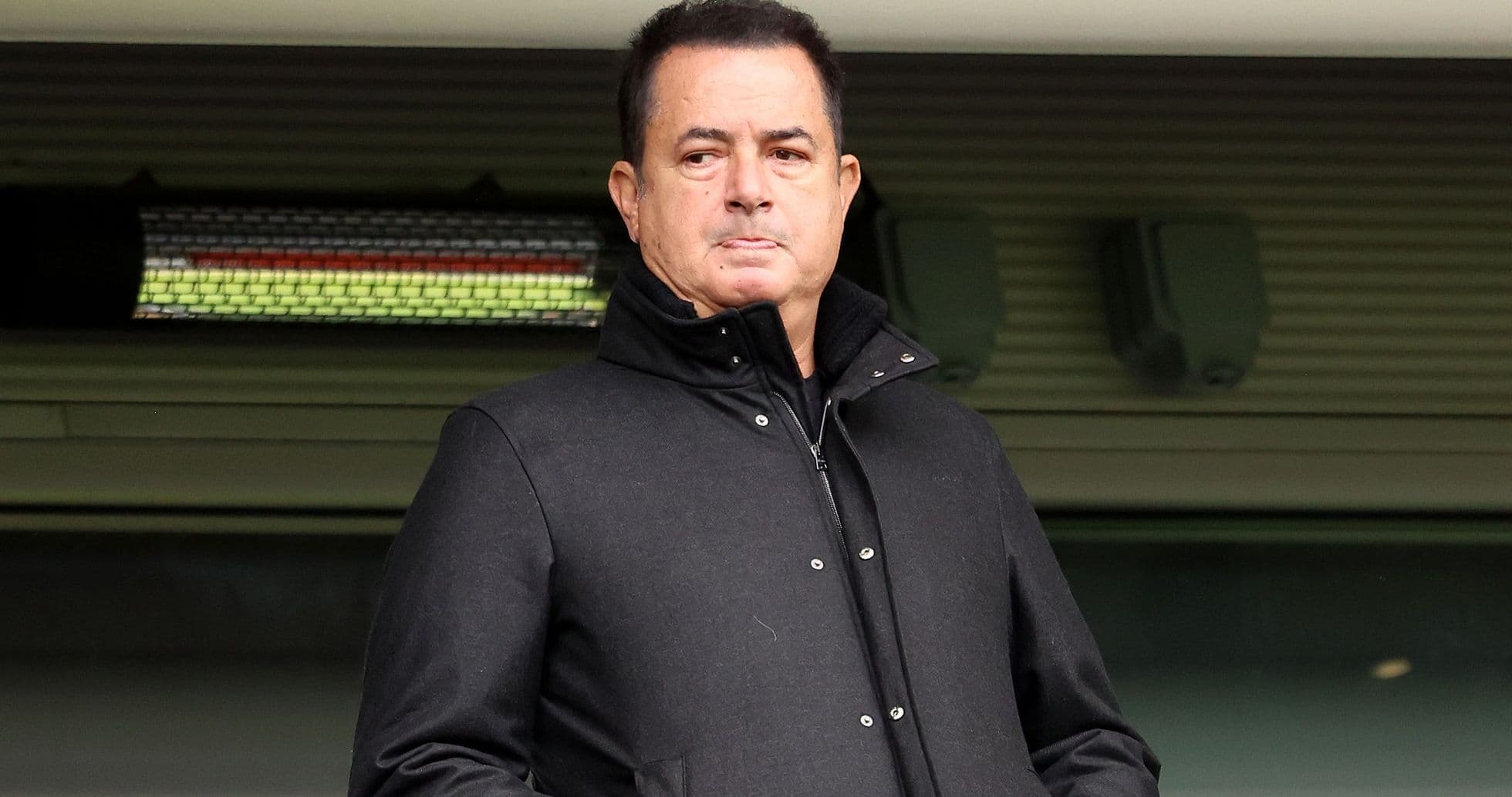Man in black coat standing at stadium