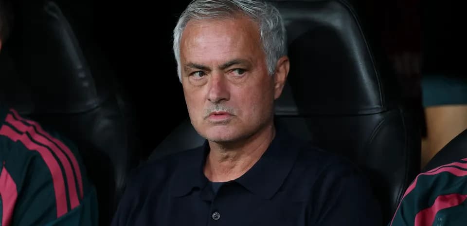 Manager seated on bench during a match
