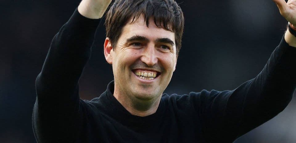 Man smiling and waving with raised hand