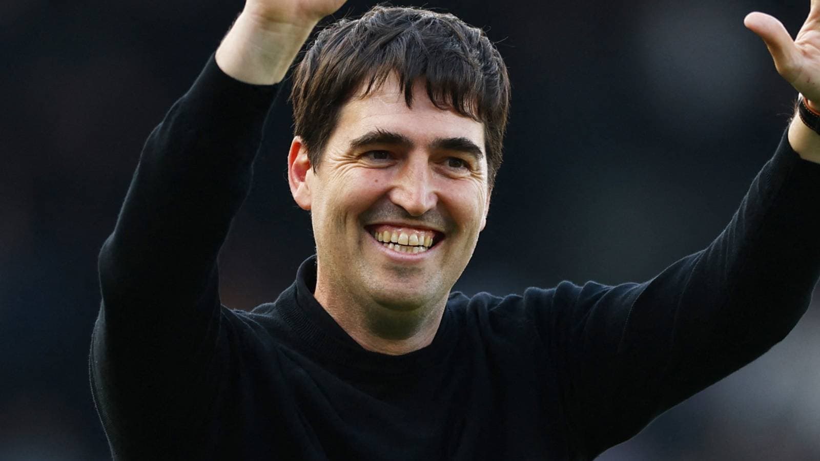 Man smiling and waving with raised hand