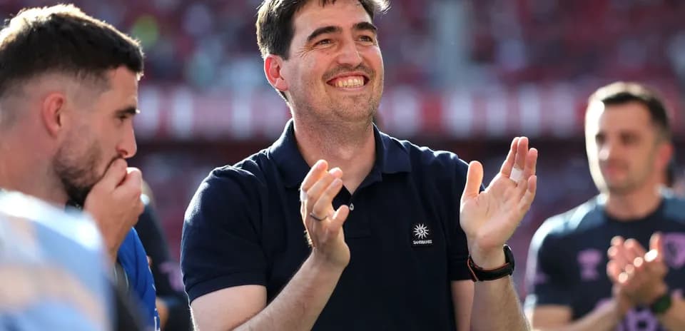 Coach applauding with players in background