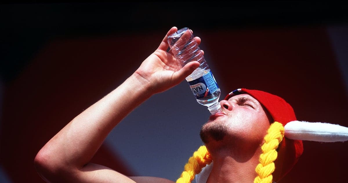 Person drinking water from a bottle outdoors