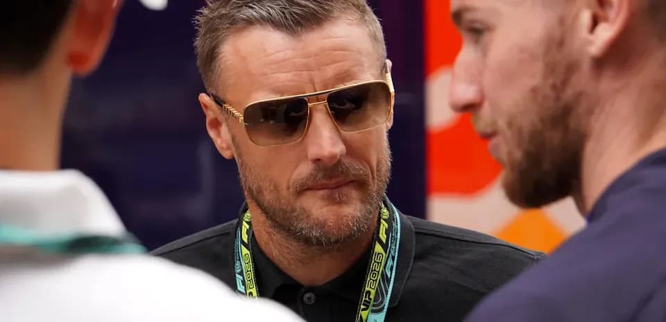 Man wearing sunglasses conversing with two others