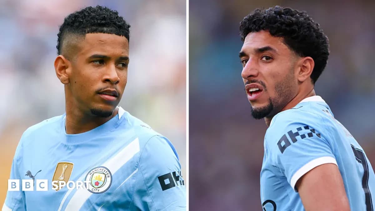 Two Manchester City players in light blue jerseys