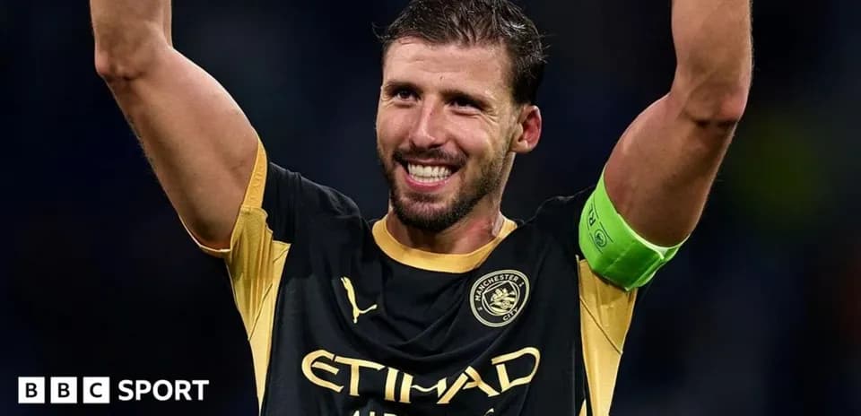 Player celebrating with raised arms in Manchester City kit