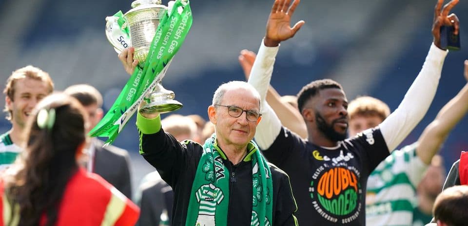 Man holding trophy with celebrating teammates around