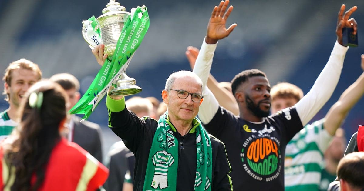 Man holding trophy with celebrating teammates around