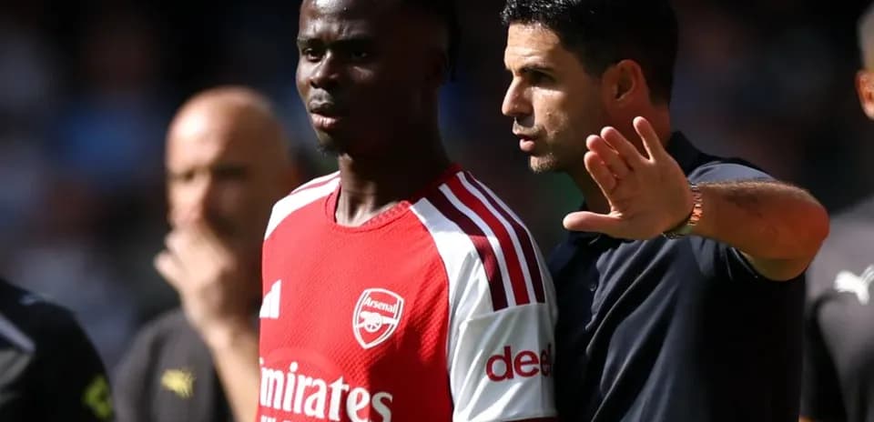 Arsenal player receiving instructions from manager during match