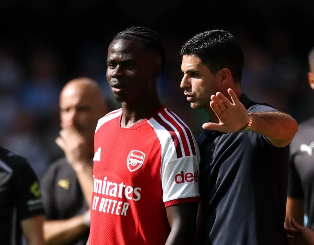 Arsenal player receiving instructions from manager during match