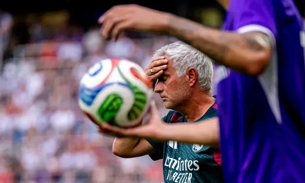 Coach with hand on forehead near soccer ball Coach with hand on forehead near soccer ball