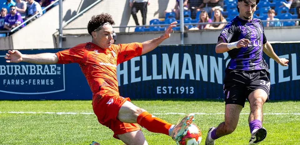 Player tackling opponent during Forge vs Pacific FC match